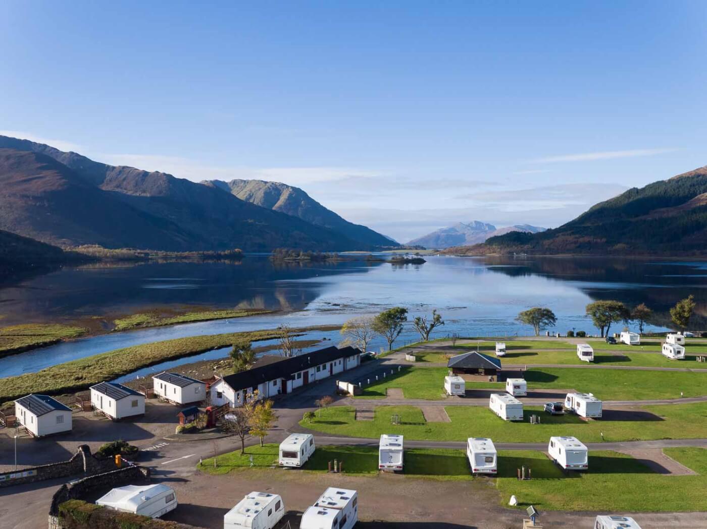Vista aérea del Invercoe Caravan and Motorhome Park junto a un loch escocés rodeado de montañas