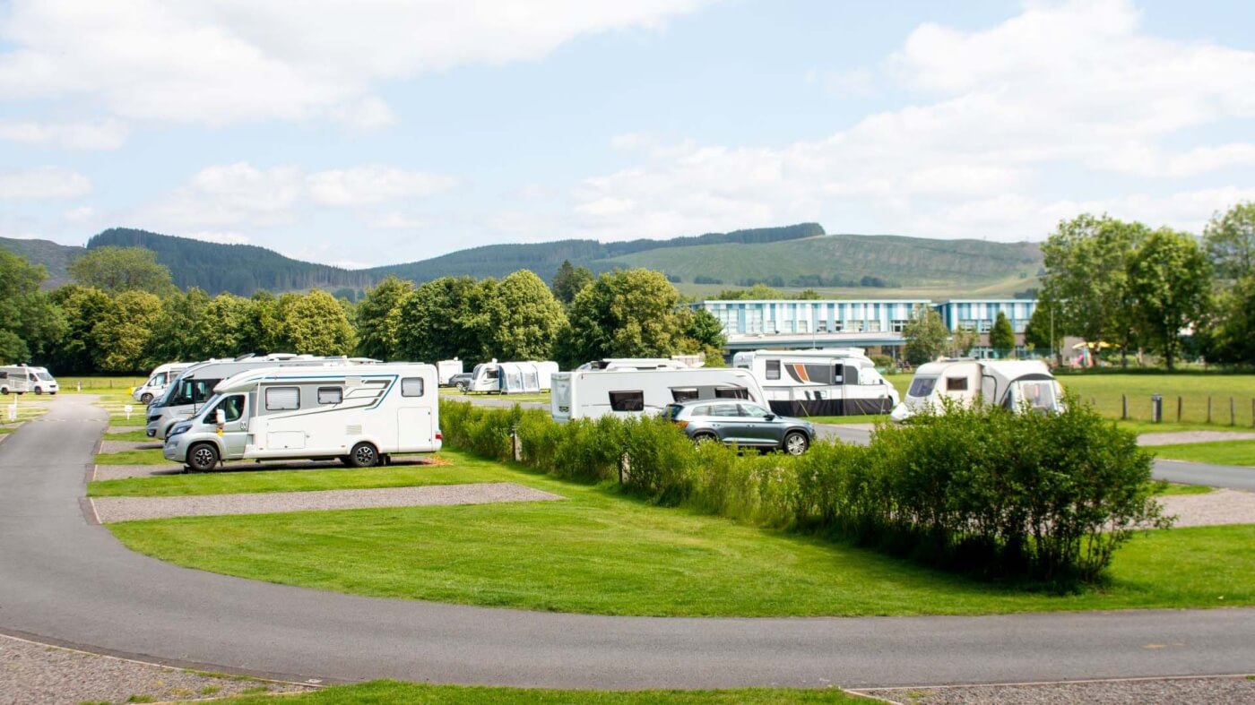 Autocaravanas y caravanas en el Moffat Camping and Caravanning Club Site con montañas verdes al fondo
