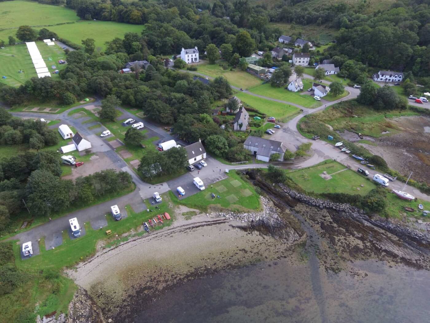 Vista aérea del camping Shieling Holidays en la isla de Mull junto a la costa con casas y árboles