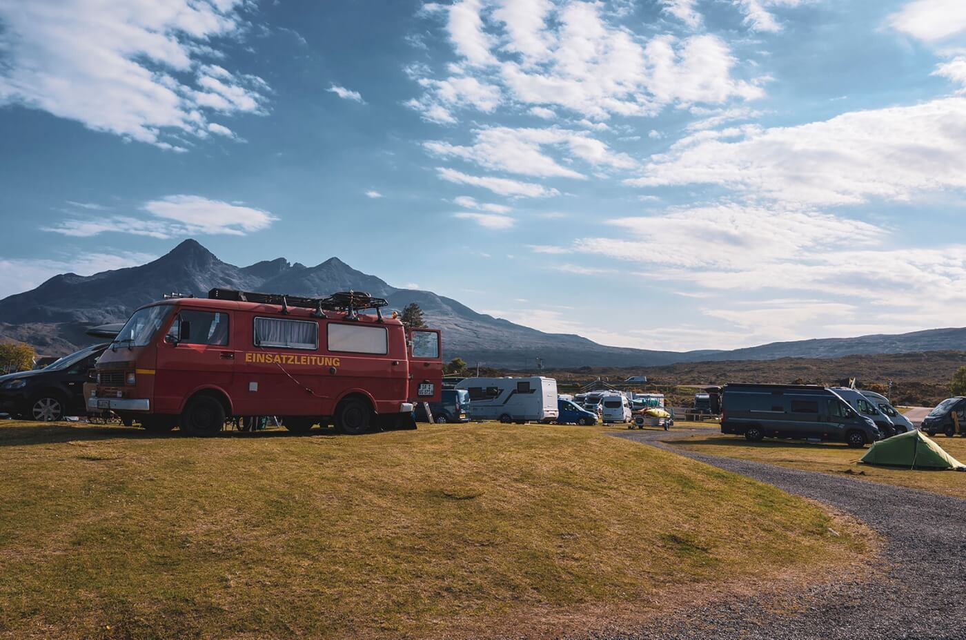 Camping en Sligachan con vehículos estacionados y las montañas Cuillin de Skye al fondo