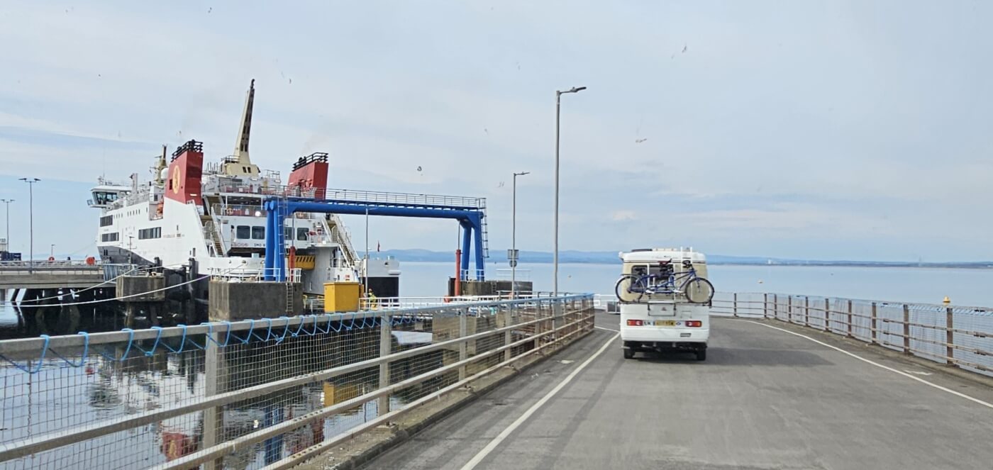 Autocaravana con bicicletas en la vía de acceso a un ferri en Escocia.